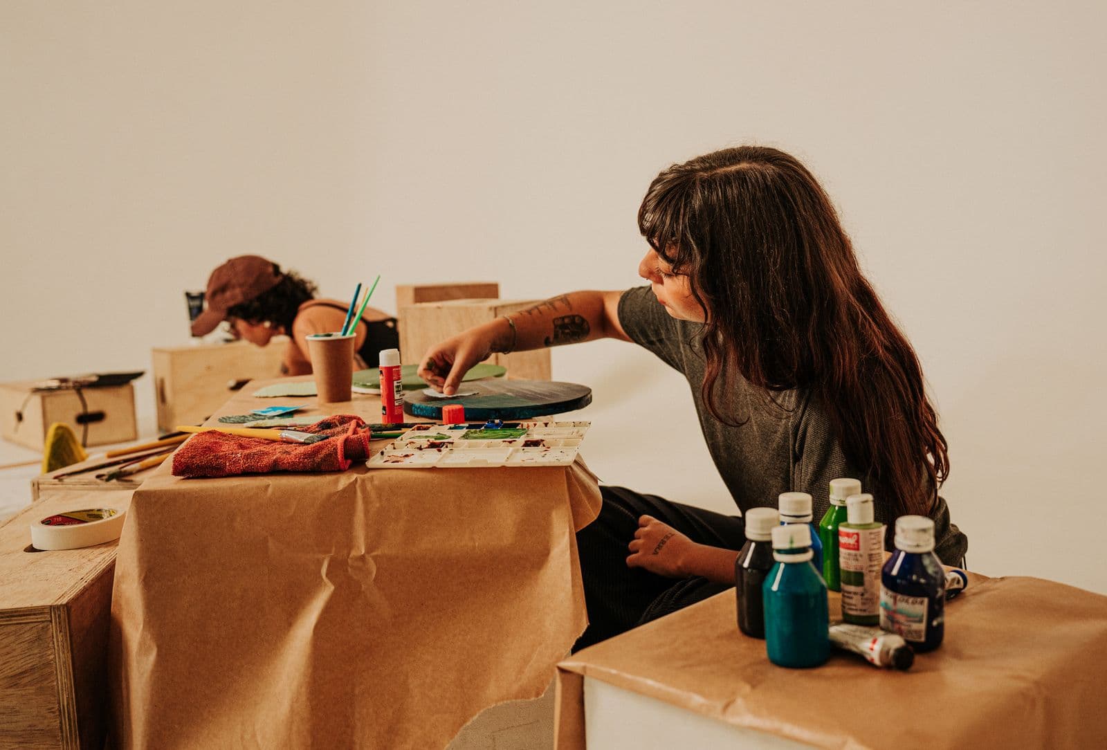 Deux personnes travaillant côte à côte sur une même table d'atelier.